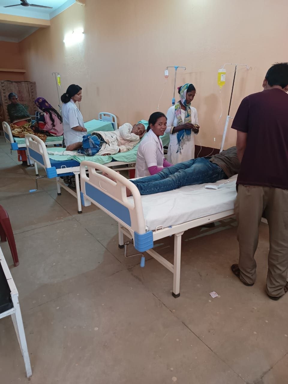 Nurses caring for patients in hospital beds